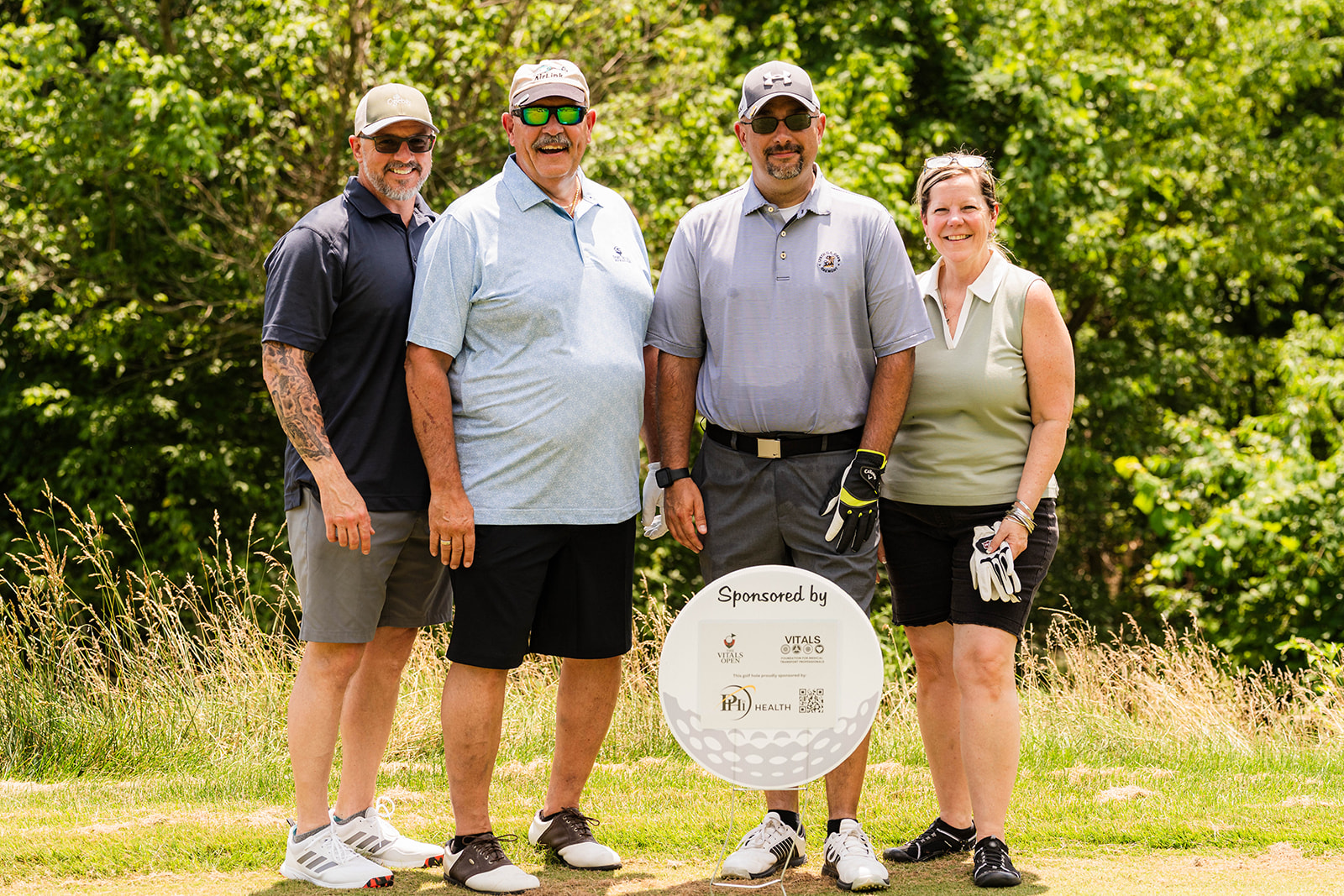 Four crew members posing together at a VITALS Open sponsored golf outing