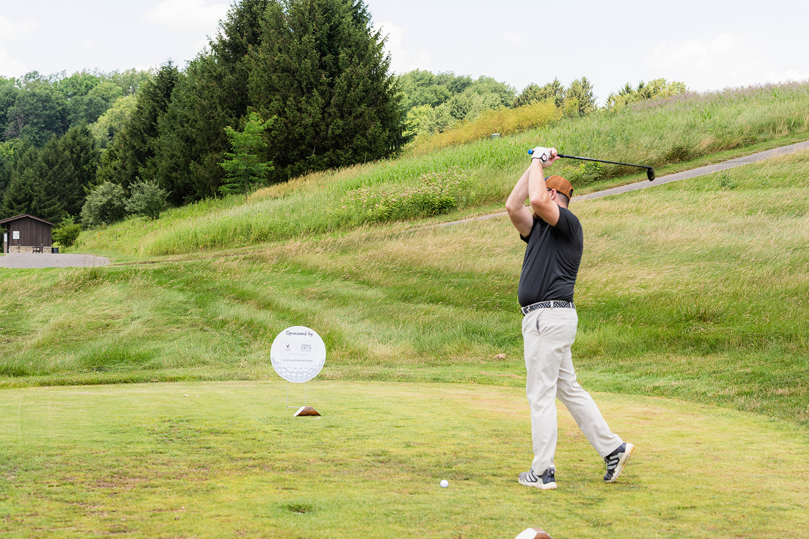 A golfer mid-swing on the tee box during the adventure day golf outing