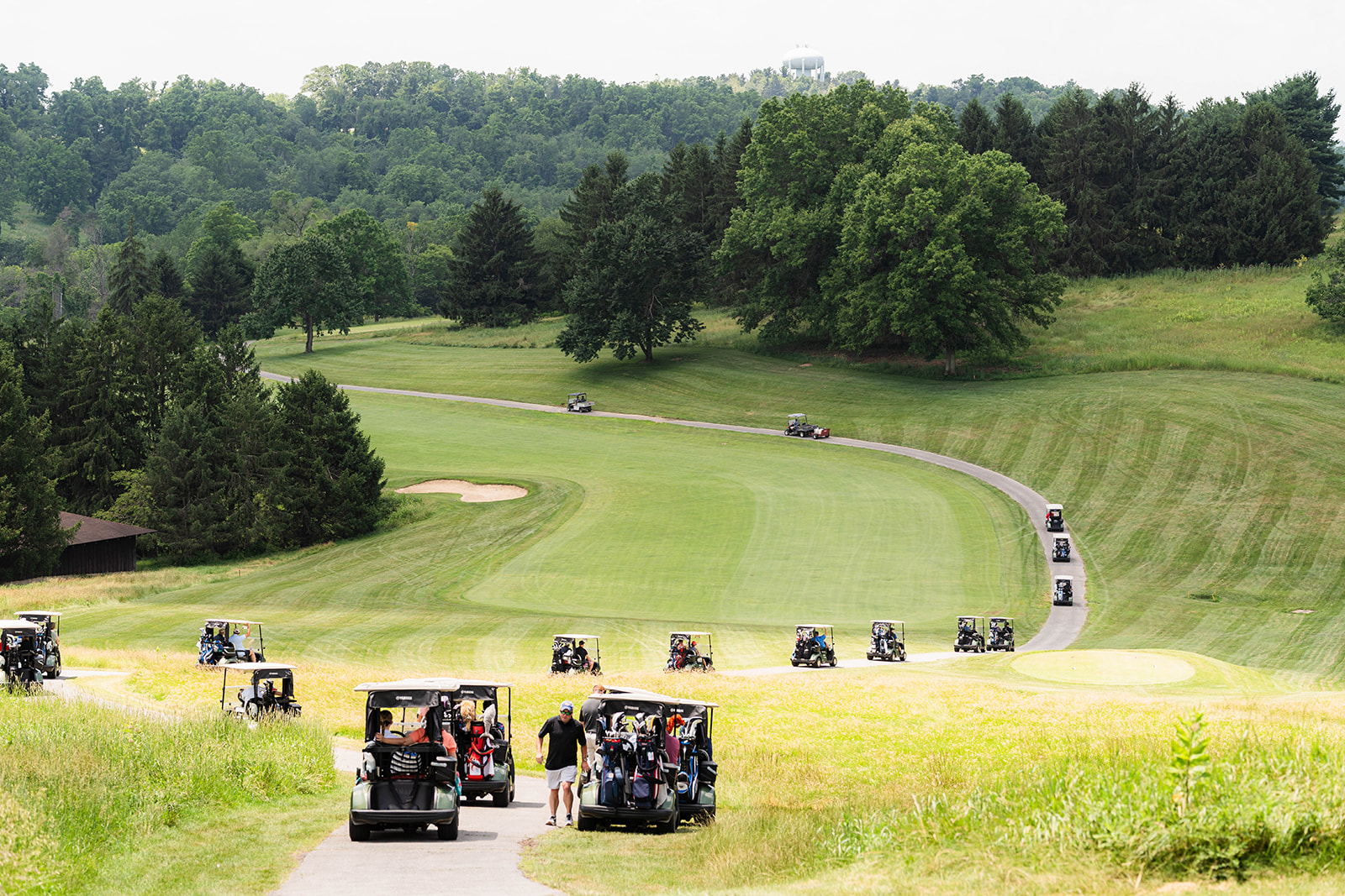 Wide view of a golf course lined with golf carts during the adventure day outing
